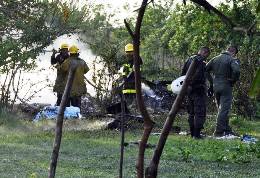 Firefighters and police officers inspect the site where a Colombian air force helicopter crashed in a rural area of the town of Sabanagrande, Colombia, Monday, April 30, 2012. Two officials who spoke on condition they not be further identified put the death toll at 13. Both say they were not authorized to disclose the number. (AP Photo) 