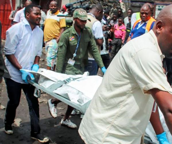 Rescuers remove bodies from the debris of an aircraft that crashed into two residential homes. (AP Photo/Justin Kabumba)